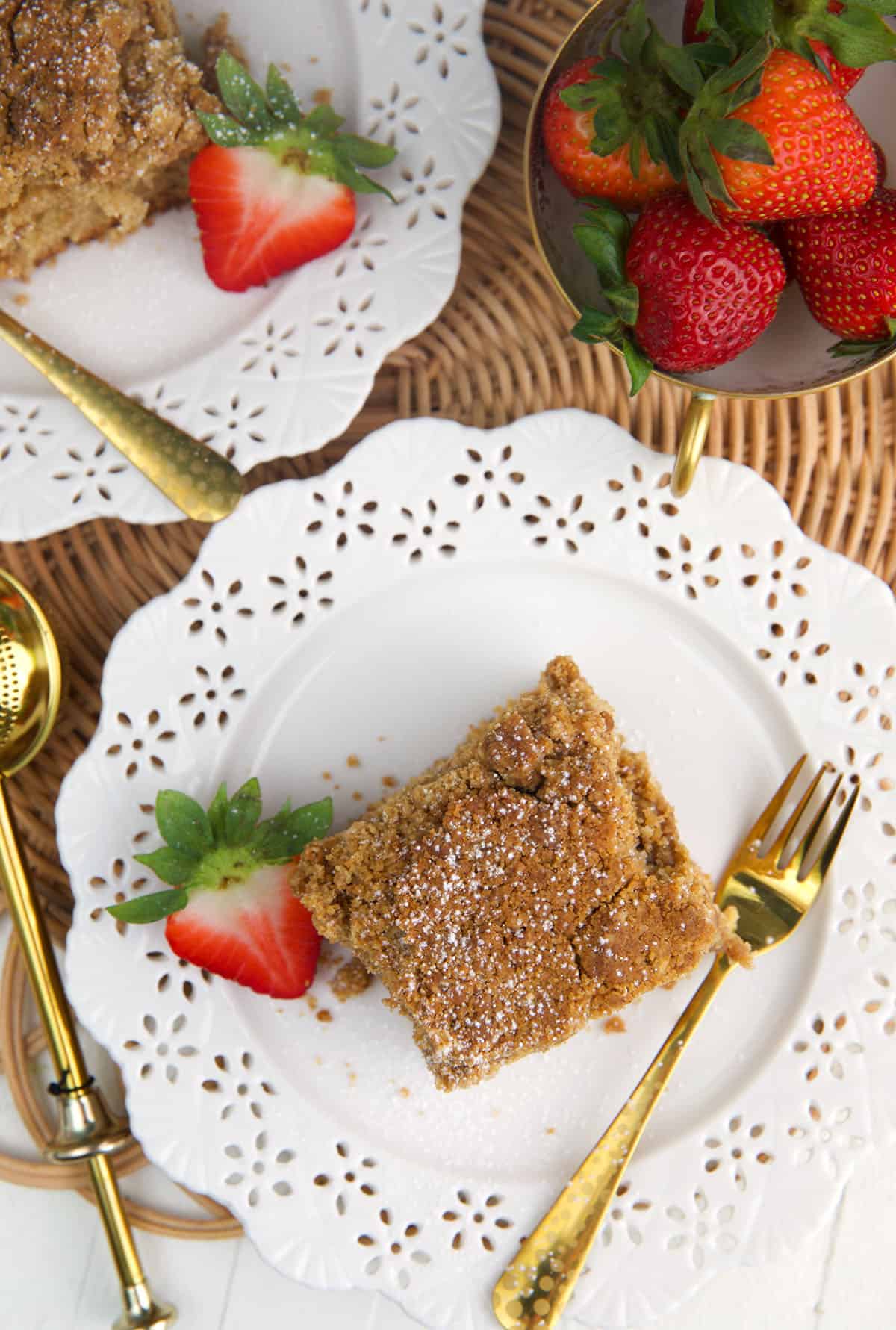 A white plate is topped with cinnamon crumb cake. 