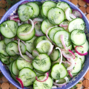 A large bowl is filled with cucumber onion salad.