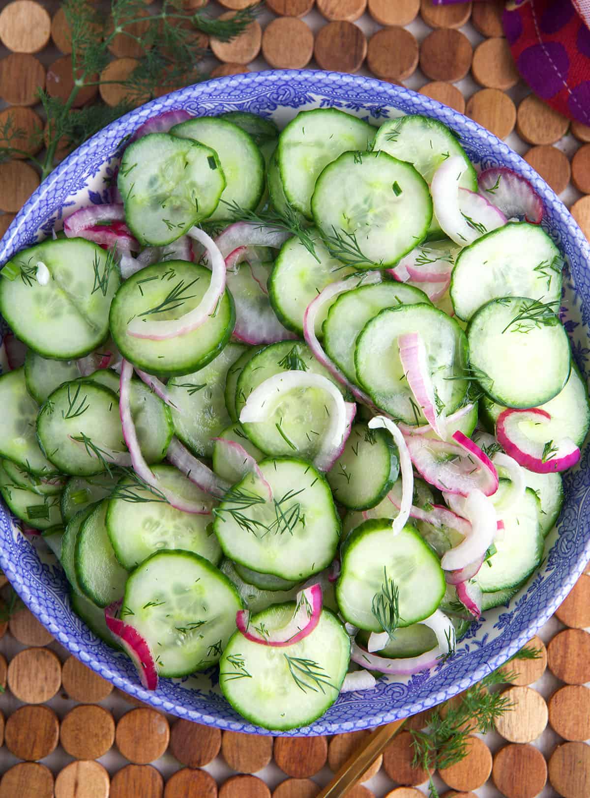 A large bowl is filled with cucumber onion salad. 