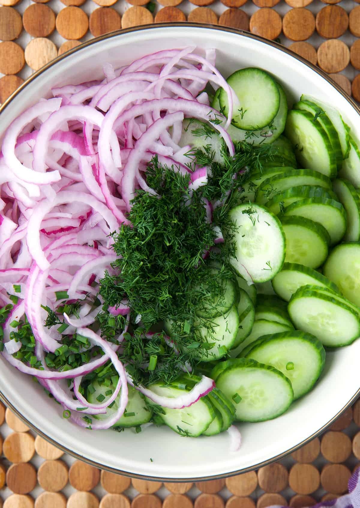 The ingredients for cucumber onion salad are placed in a bowl. 