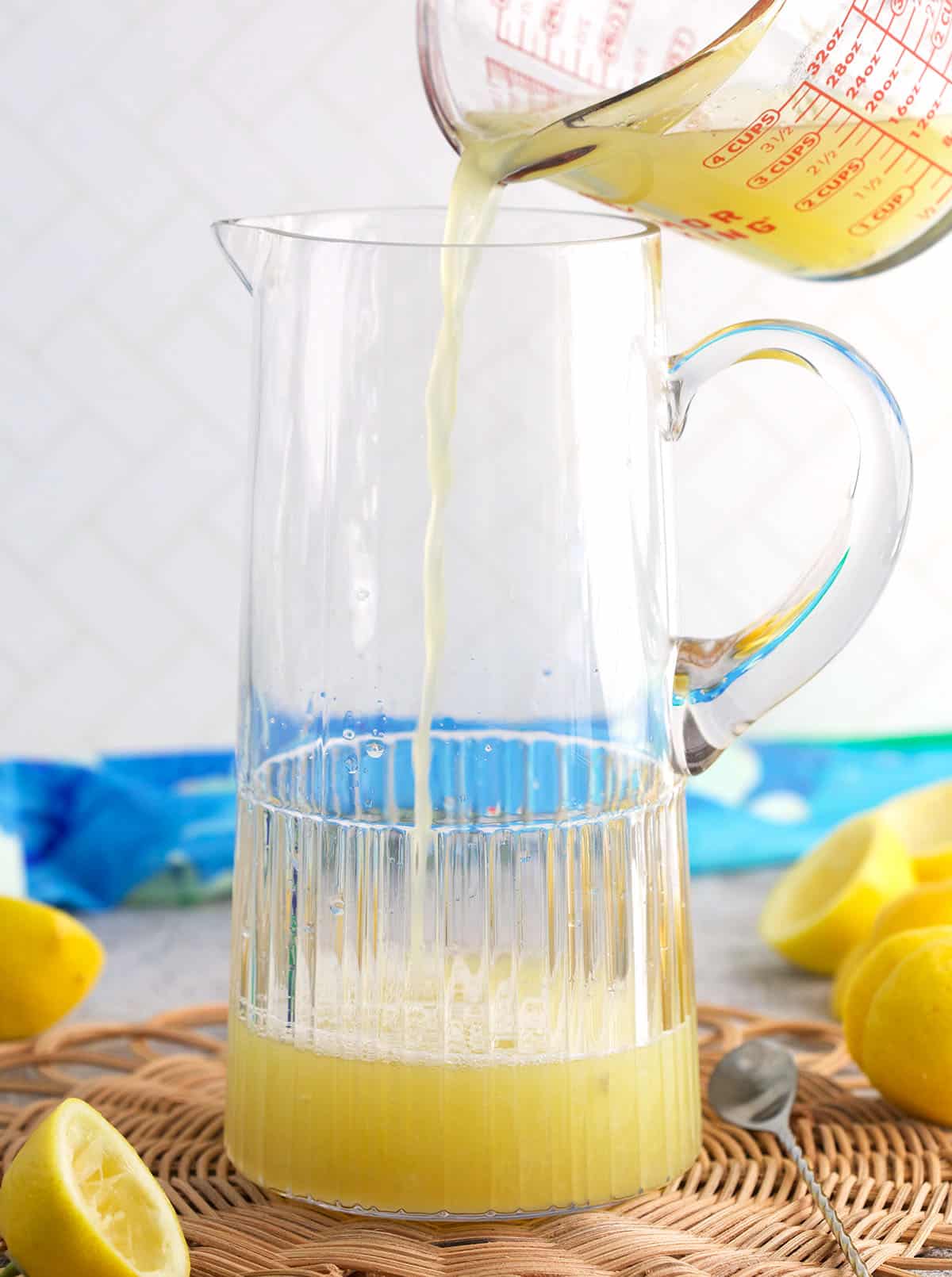 Lemon juice being poured into a glass pitcher.