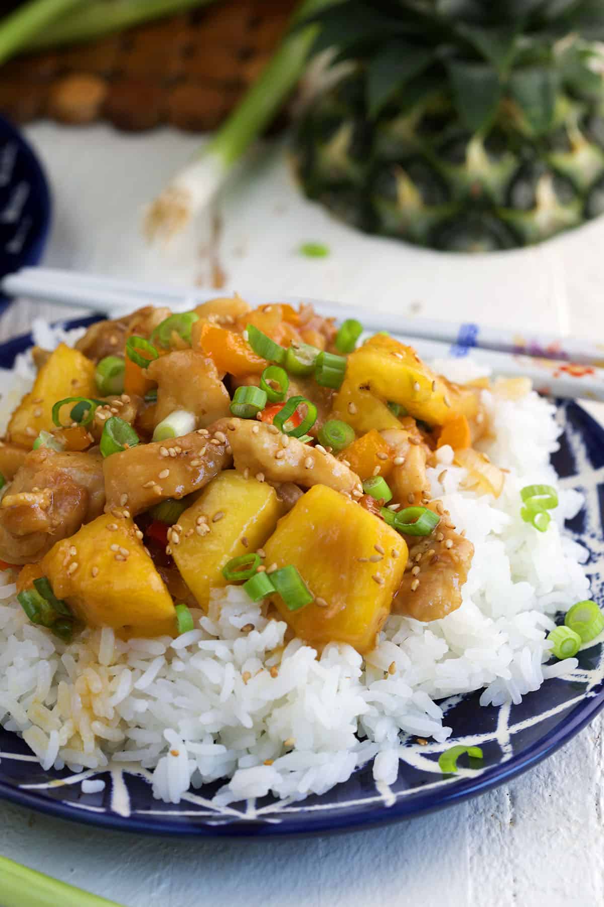 Pineapple chicken is placed on top of a serving of white rice. 