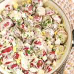 A bowl of red potato salad is full.