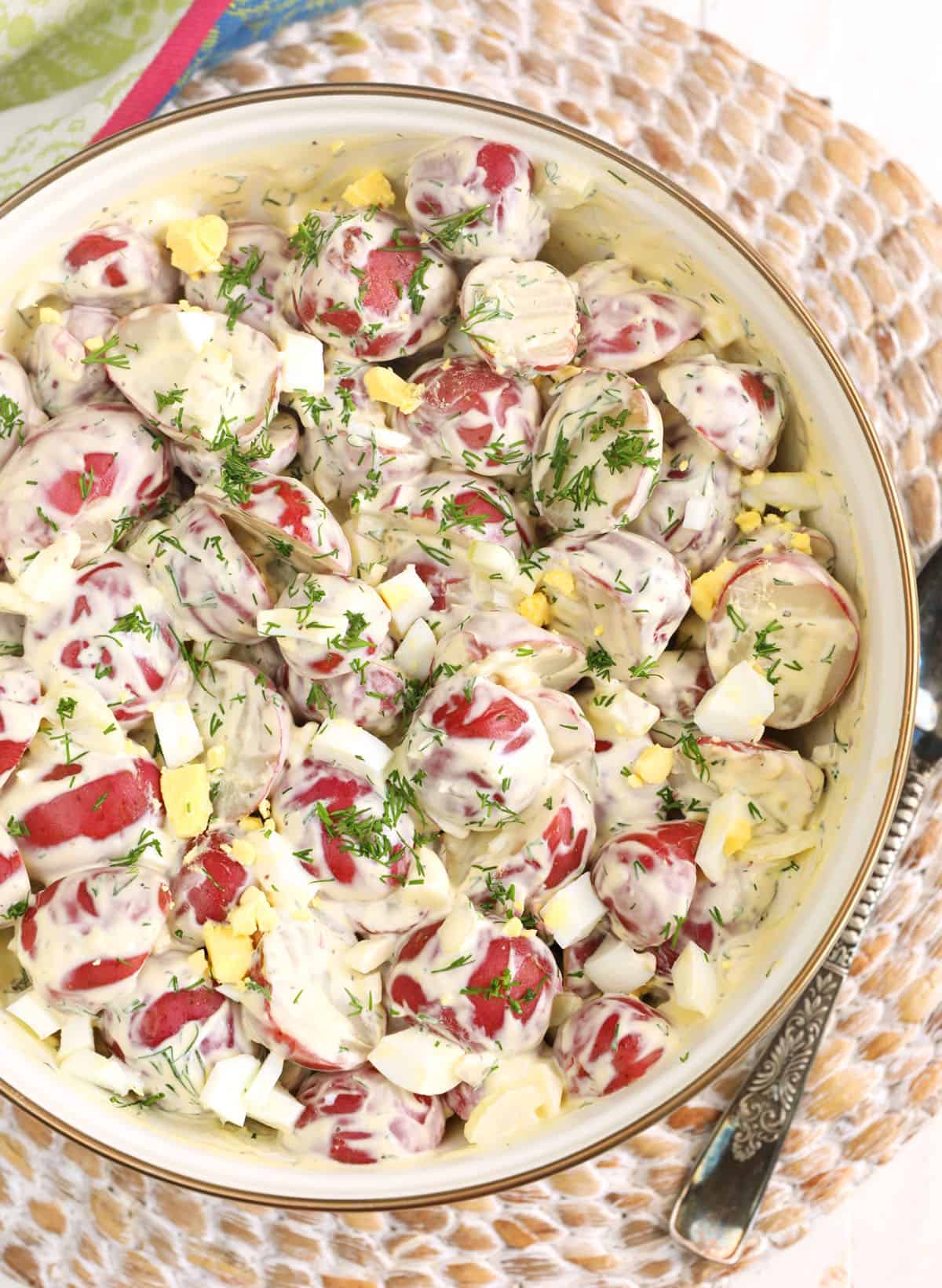 A bowl of red potato salad is full. 