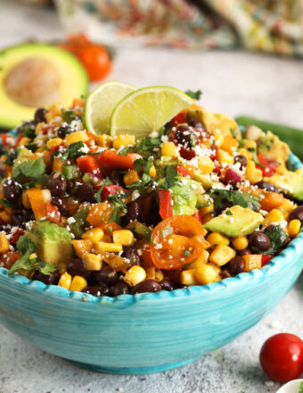 Black bean salad in serving bowl with lime wedges for garnish