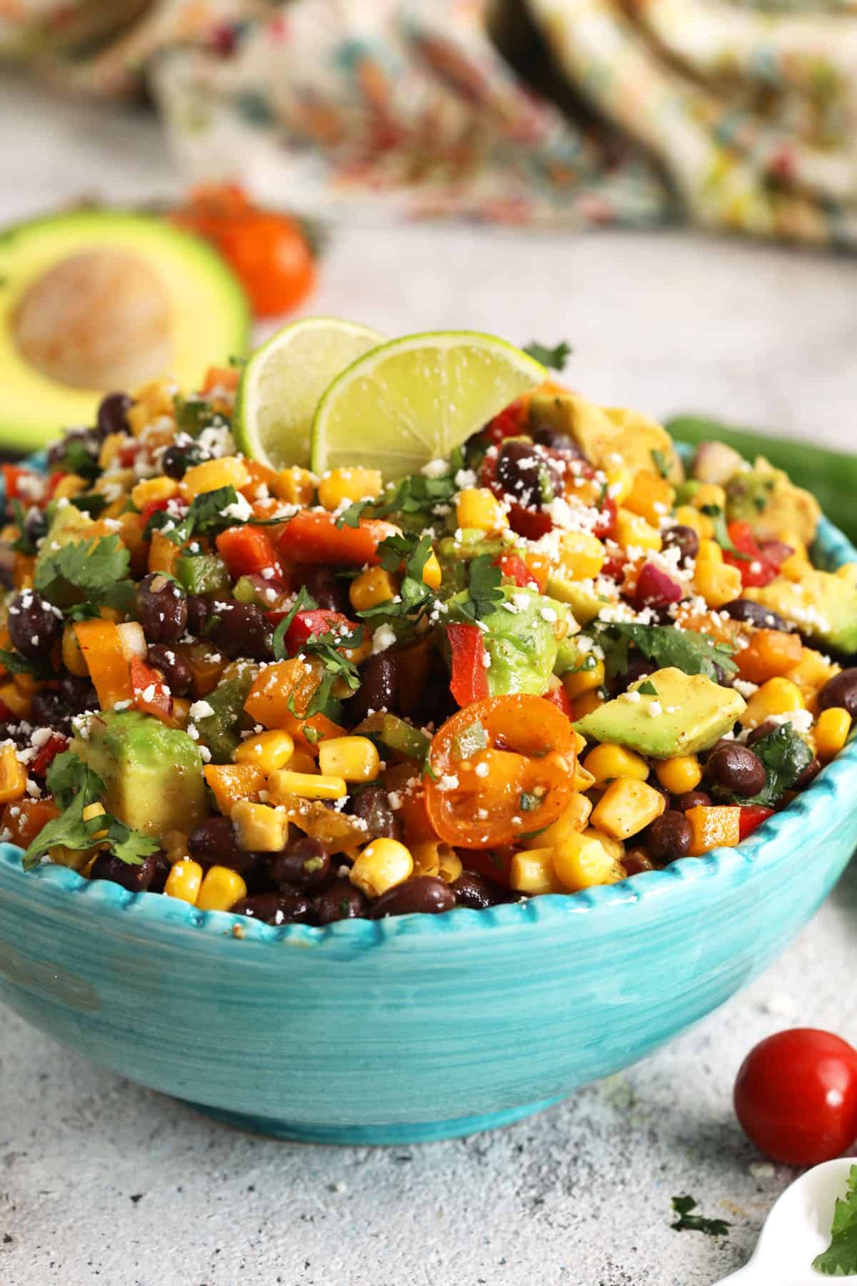 Black bean salad in serving bowl with lime wedges for garnish