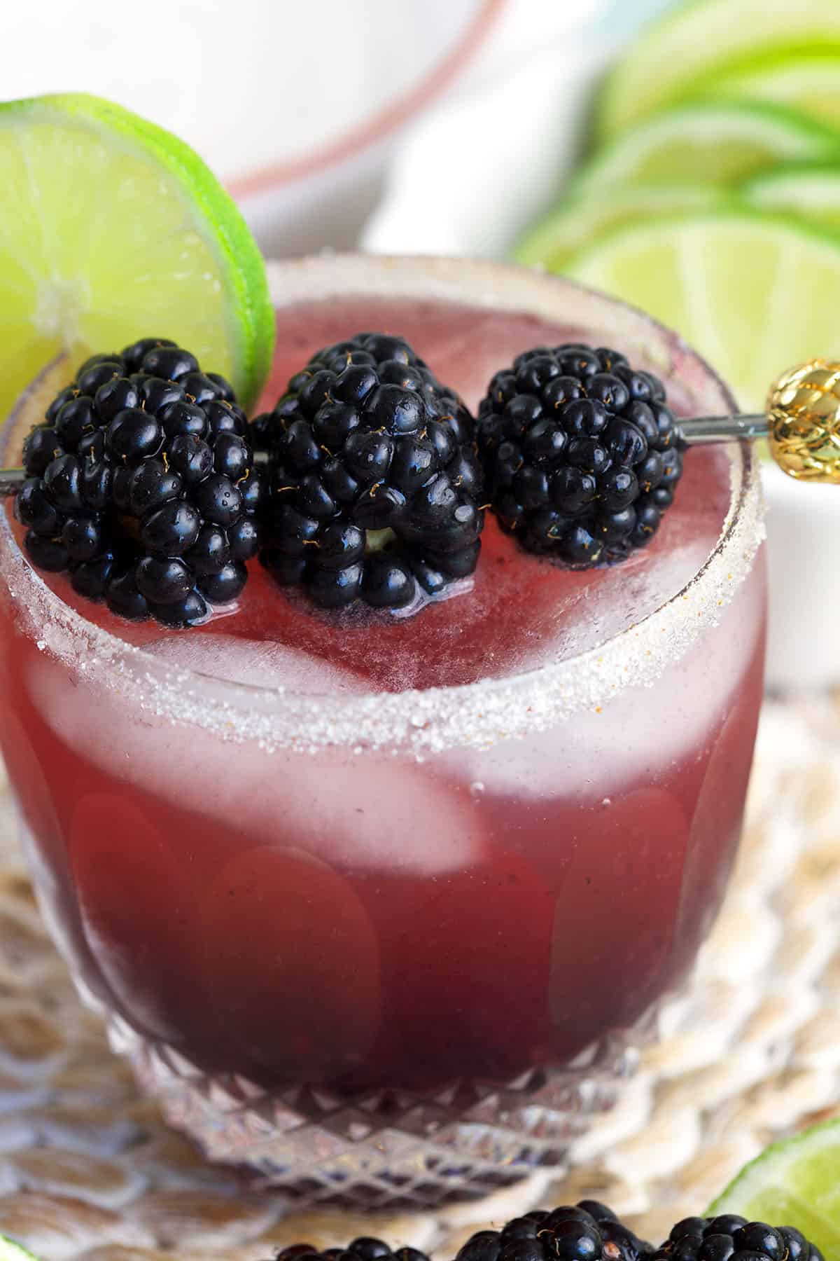 Closeup of blackberry margarita in glass with salted rim