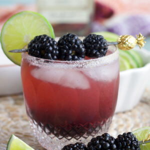 Blackberry margarita in glass with blackberries and lime wheel for garnish