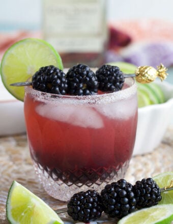Blackberry margarita in glass with blackberries and lime wheel for garnish