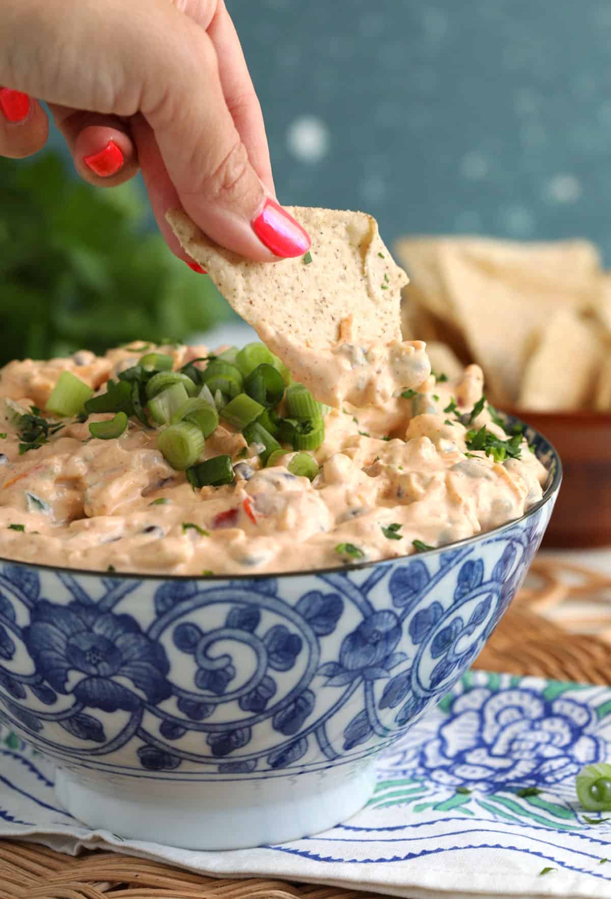 Dipping tortilla chip into boat dip