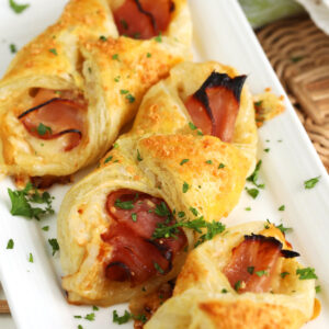 Ham and cheese croissants on white serving platter