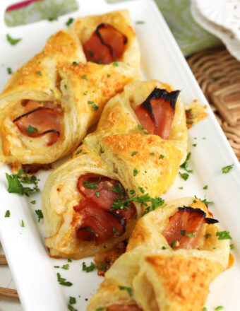 Ham and cheese croissants on white serving platter