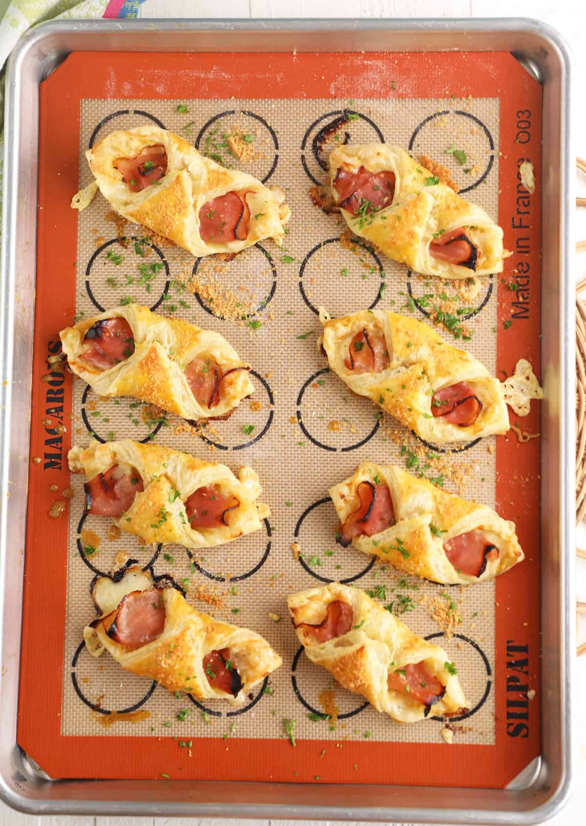 Overhead view of ham and cheese croissants on baking sheet