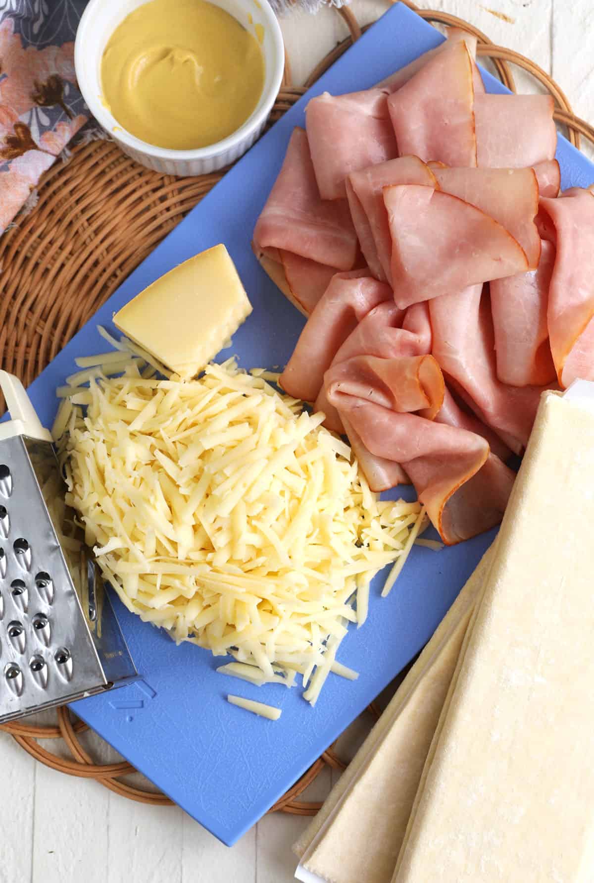 Ingredients for ham and cheese croissants, including ham slices and gruyere cheese