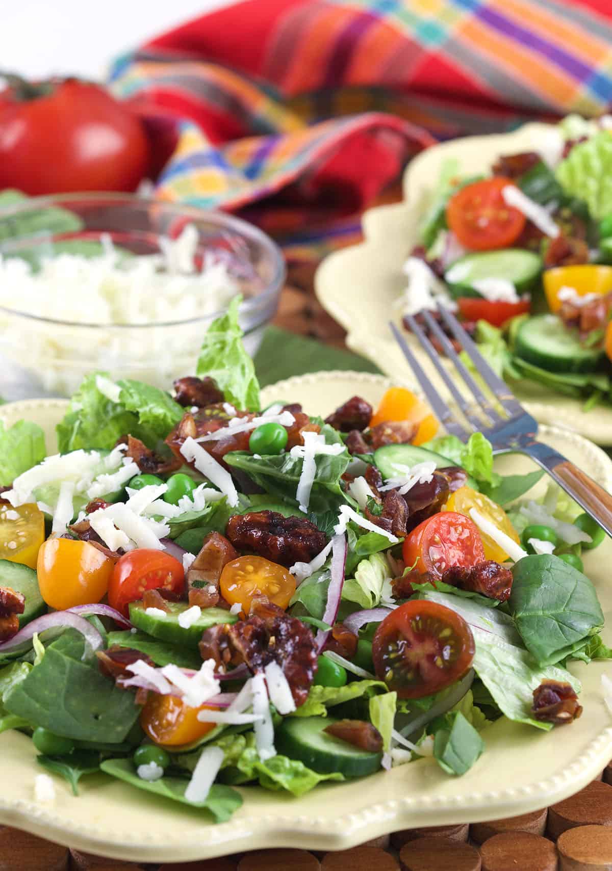 Two plates of house salad with manchego and dates