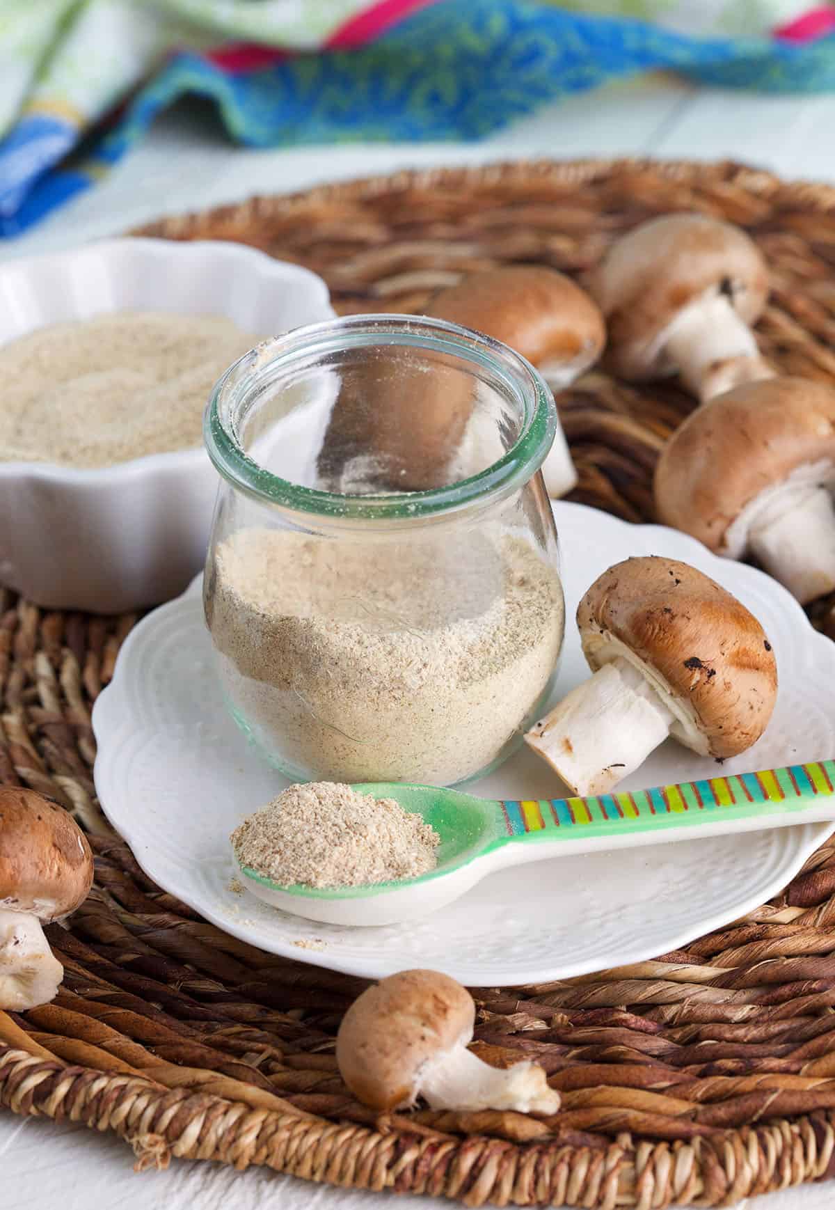 Jar and spoonful of mushroom powder on plate