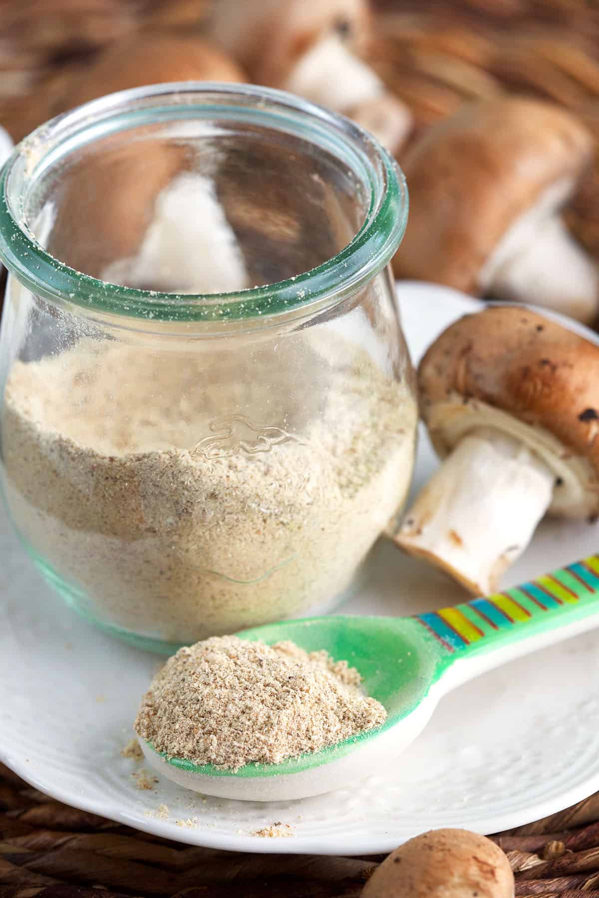 Spoon of mushroom powder set in front of jar