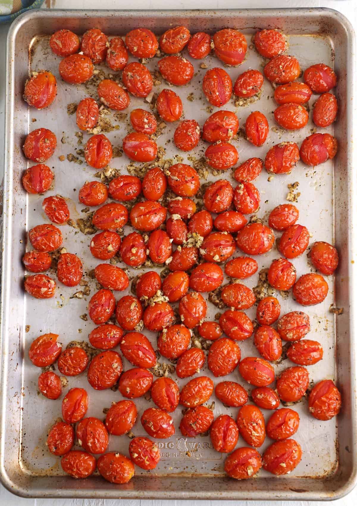 Overhead view of roasted tomatoes on sheet pan