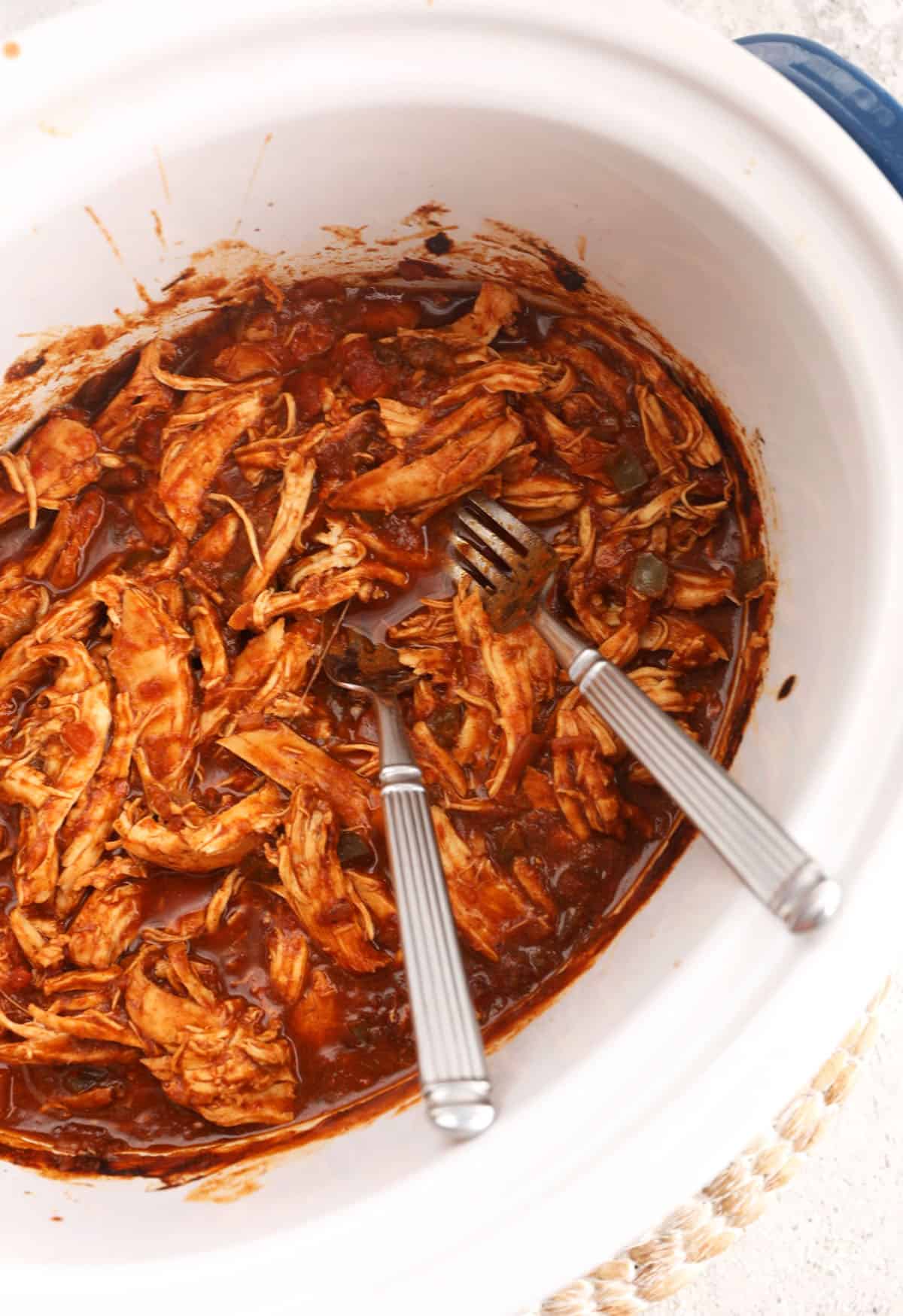 Overhead view of shredded salsa chicken in slow cooker insert