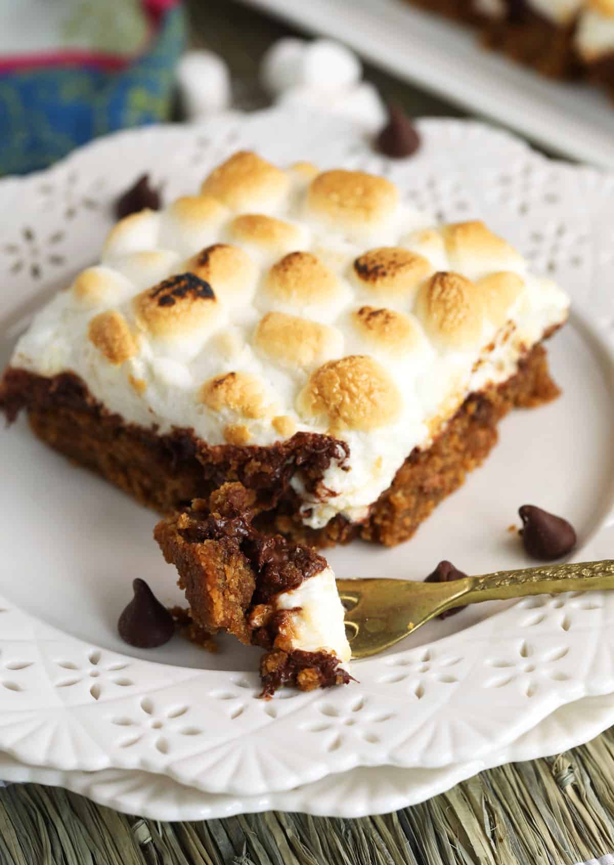 S'mores bar on a plate with a fork read with a bite on it.
