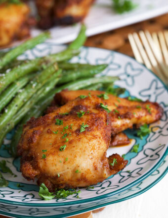 Sweet and spicy boneless chicken thighs on plate with green beans