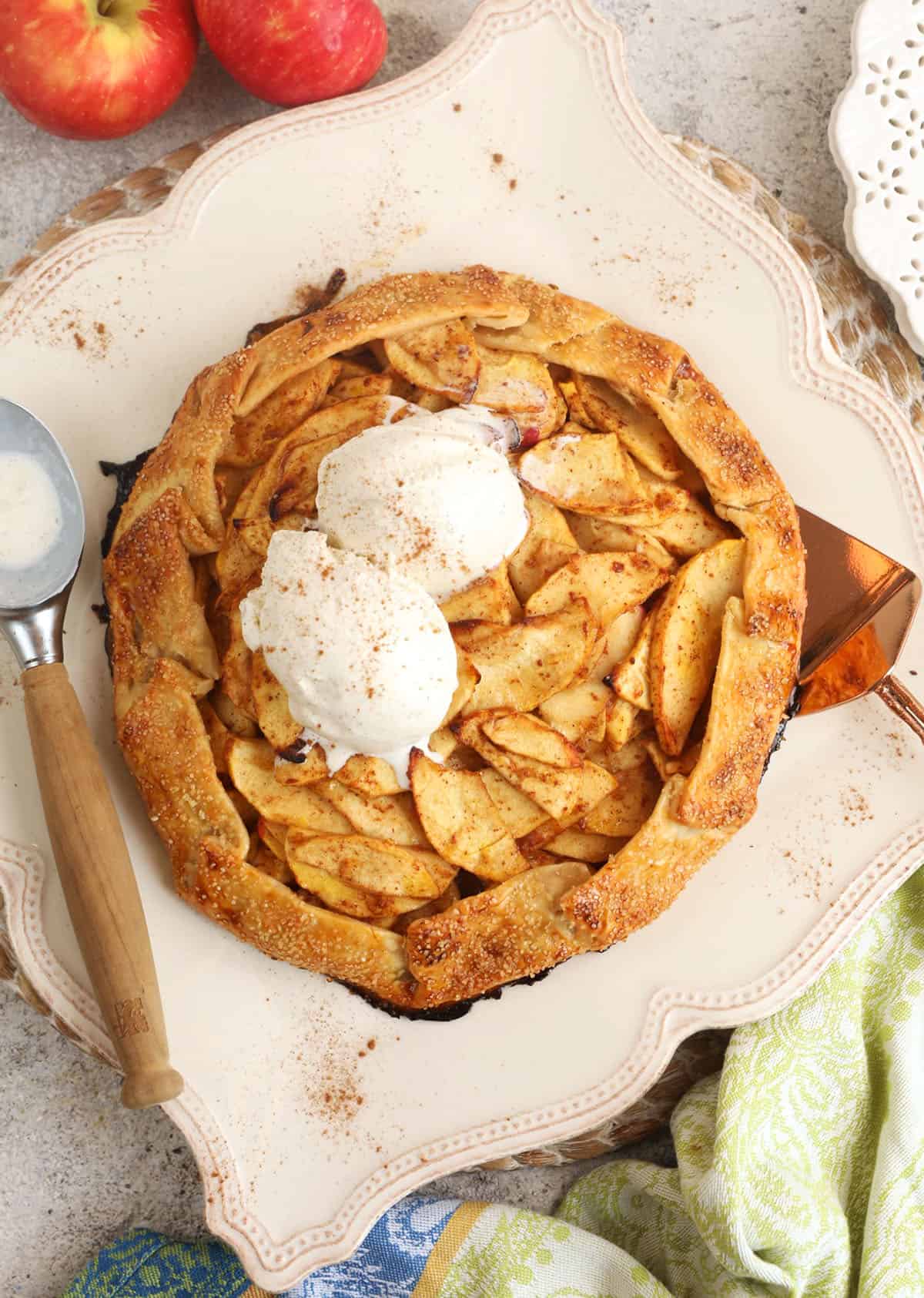 Overhead view of apple galette on platter with ice cream scoops on top