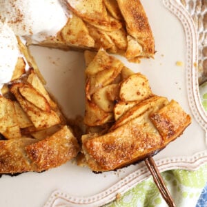 Spatula lifting slice of apple galette from platter