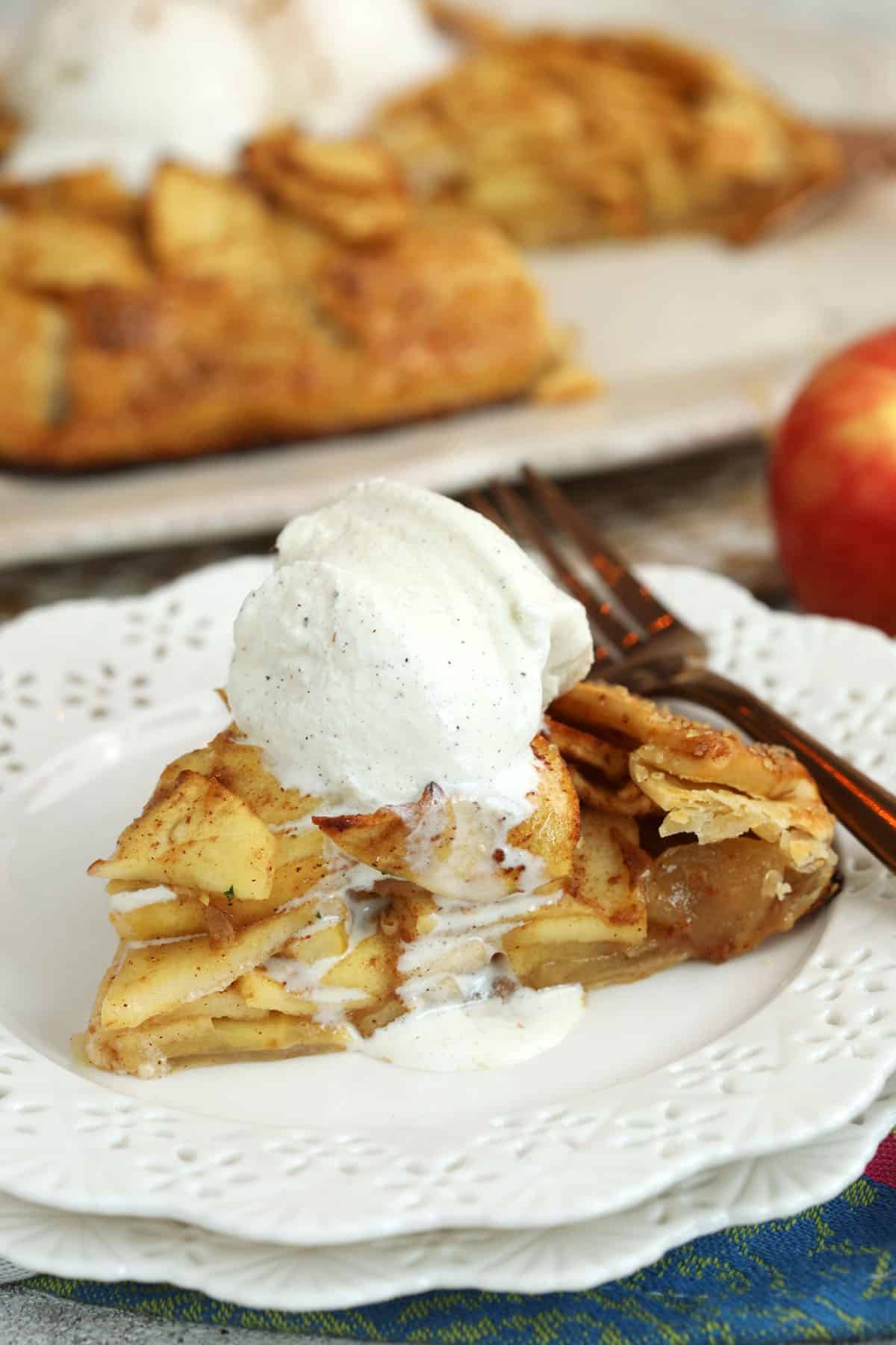 Apple galette on plate with scoop of vanilla ice cream on top