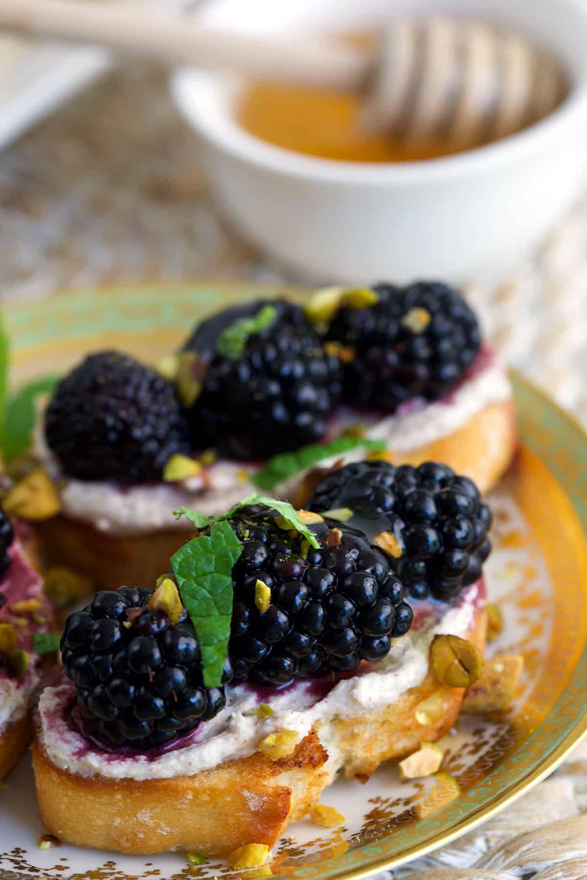 Two blackberry goat cheese crostini on plate