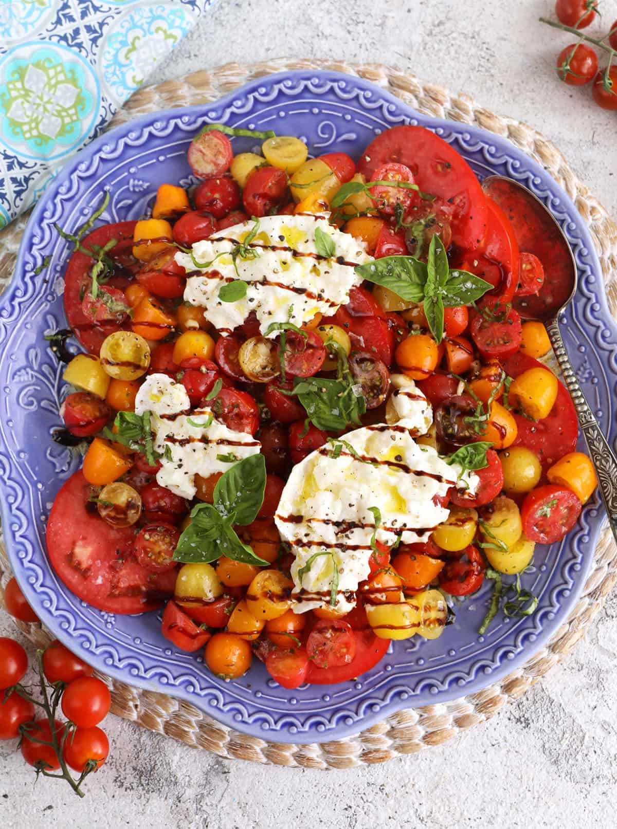 Overhead view of burrata caprese on blue serving platter