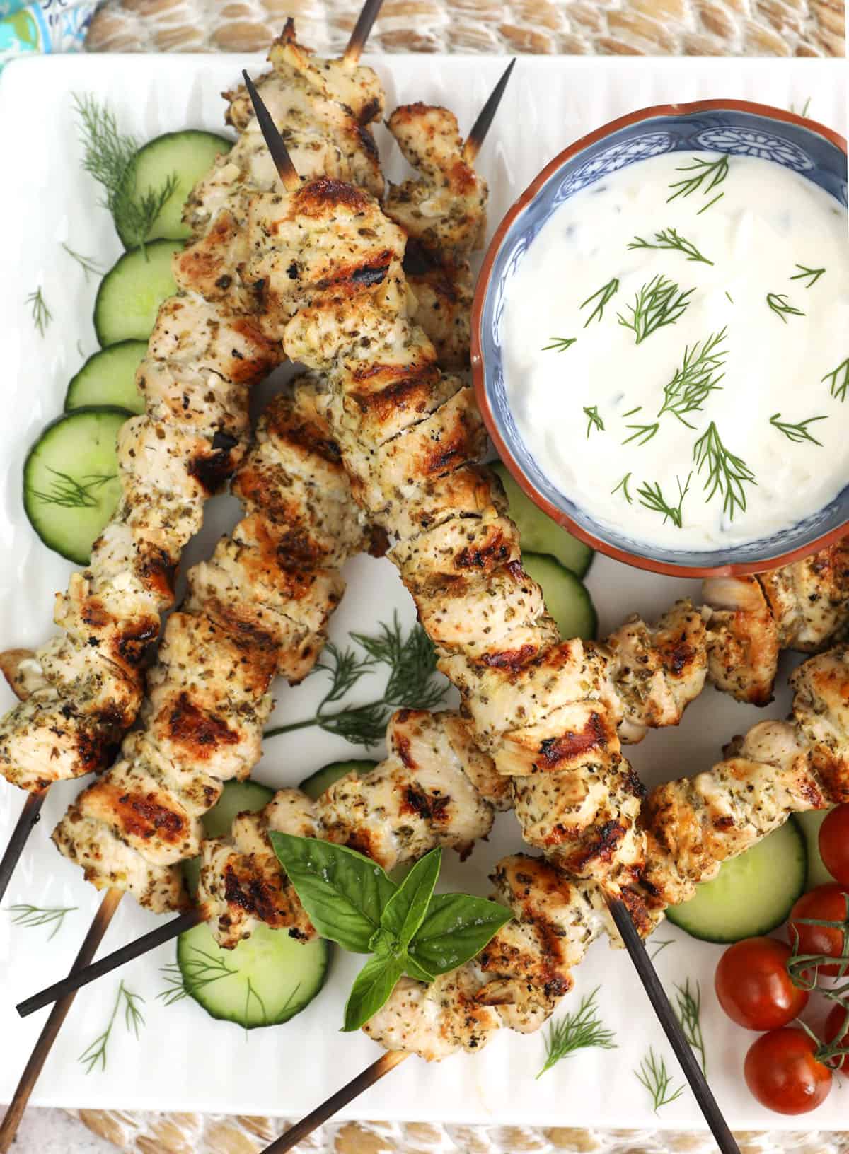 Plate of chicken souvlaki with tzatziki and cucumbers