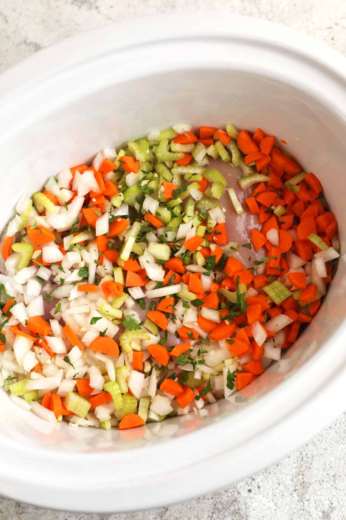 Vegetables added to slow cooker for chicken noodle soup