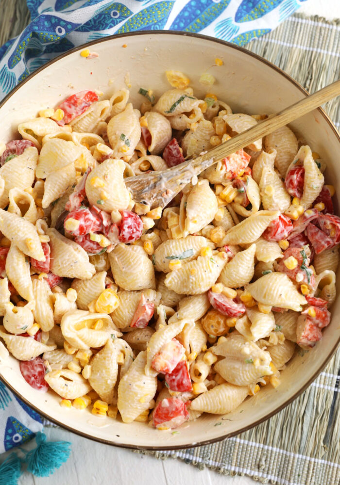 ingredients for lobster pasta salad being mixed in a bowl