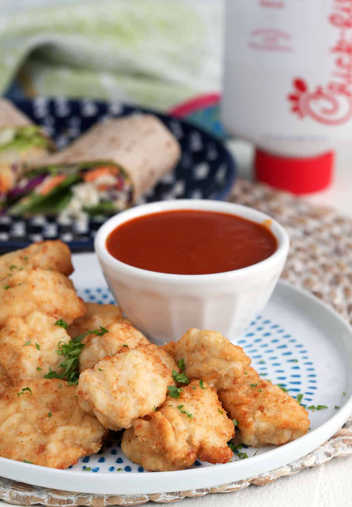 Chicken nuggets on plate with bowl of Polynesian sauce