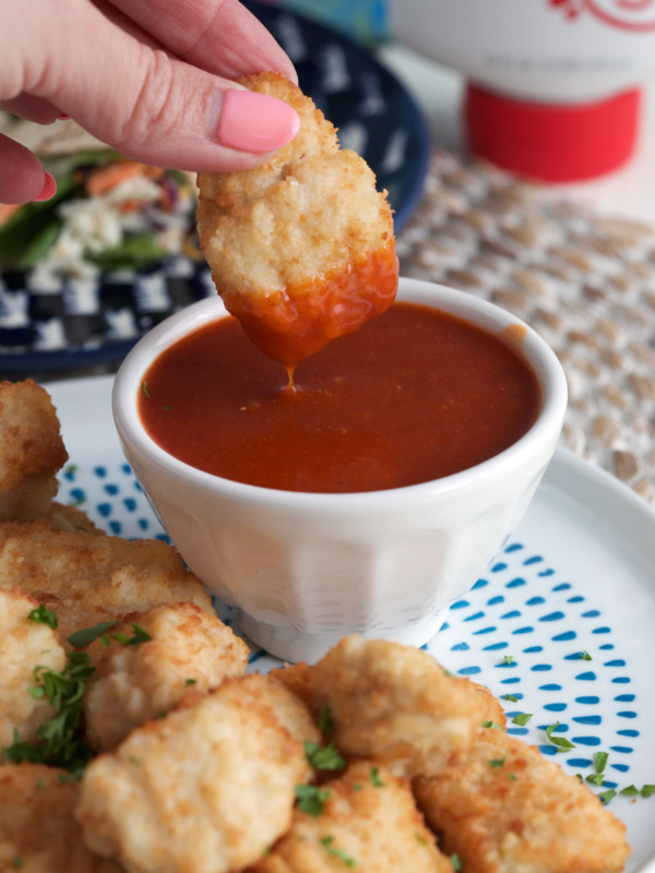 Dipping chicken nugget into homemade Polynesian sauce