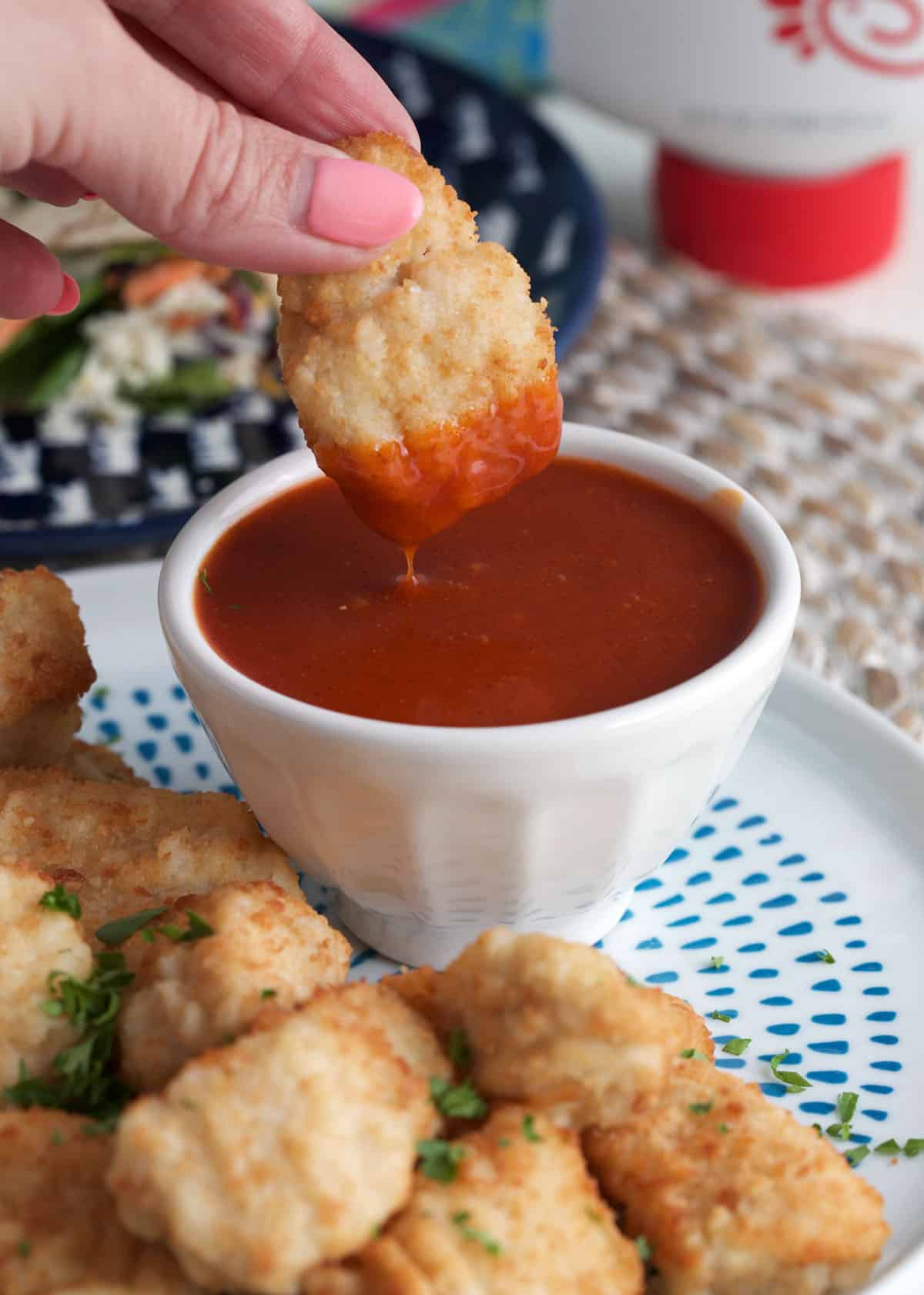 Dipping chicken nugget into homemade Polynesian sauce