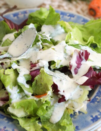 Drizzling ranch dressing onto salad