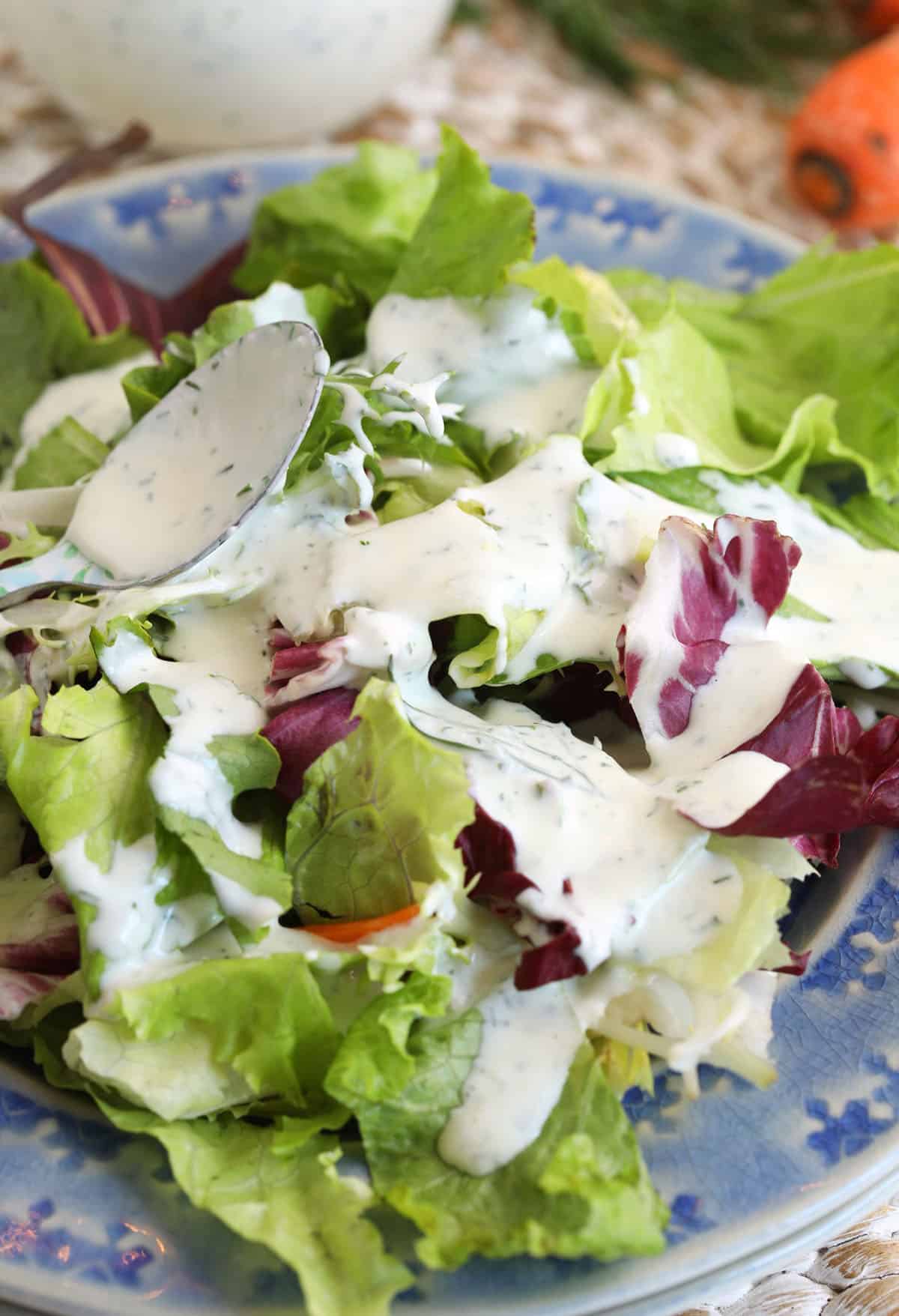 Drizzling ranch dressing onto salad