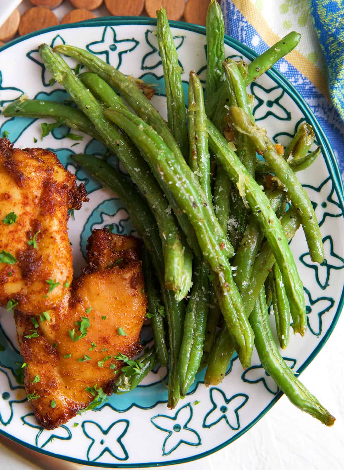 Overhead view of roasted green beans on plate with chicken