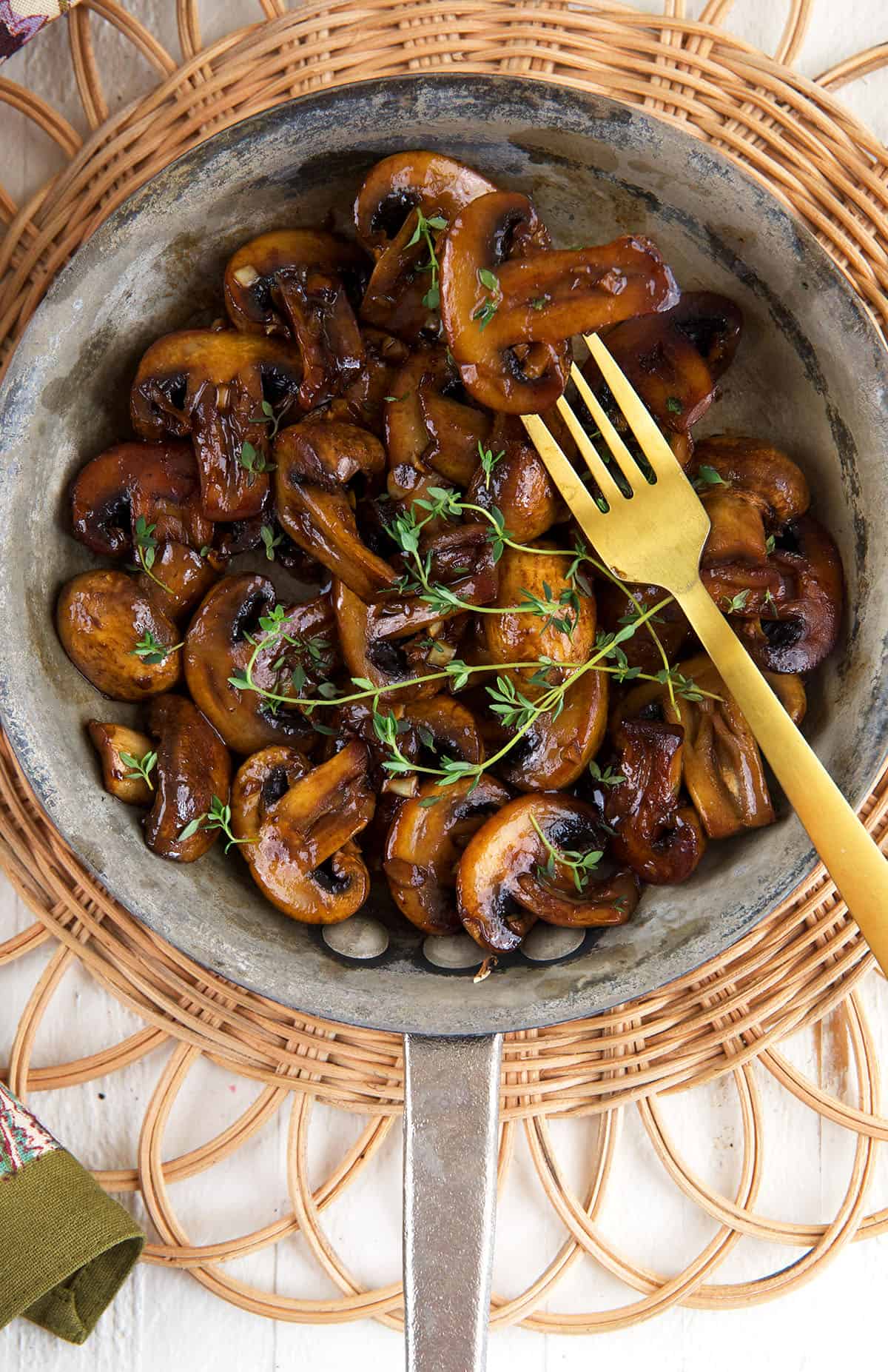 Overhead view of sauteed mushrooms in skillet with fork