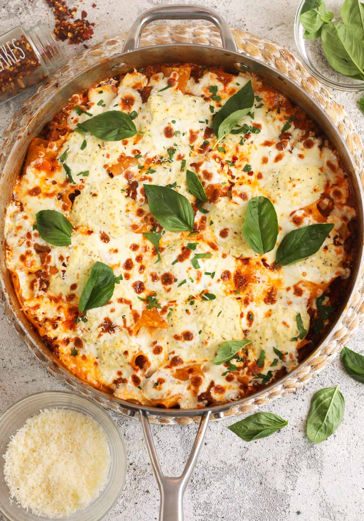 Overhead view of cheesy skillet lasagna with basil for garnish