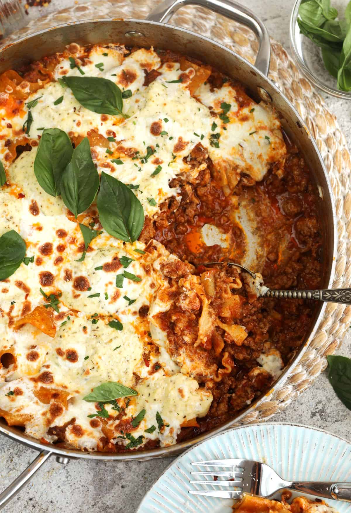 Overhead view of skillet lasagna with portion removed