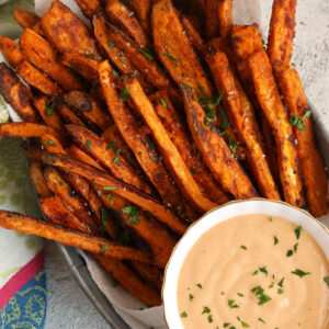 Overhead view of oven-baked sweet potato fries with dipping sauce