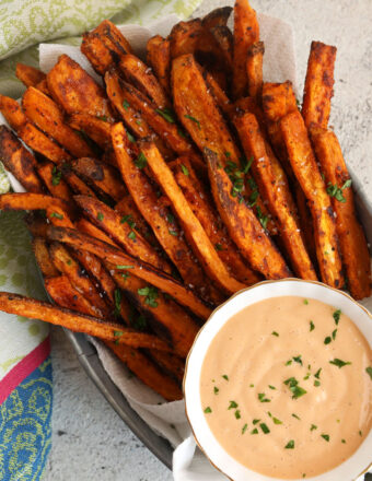 Overhead view of oven-baked sweet potato fries with dipping sauce