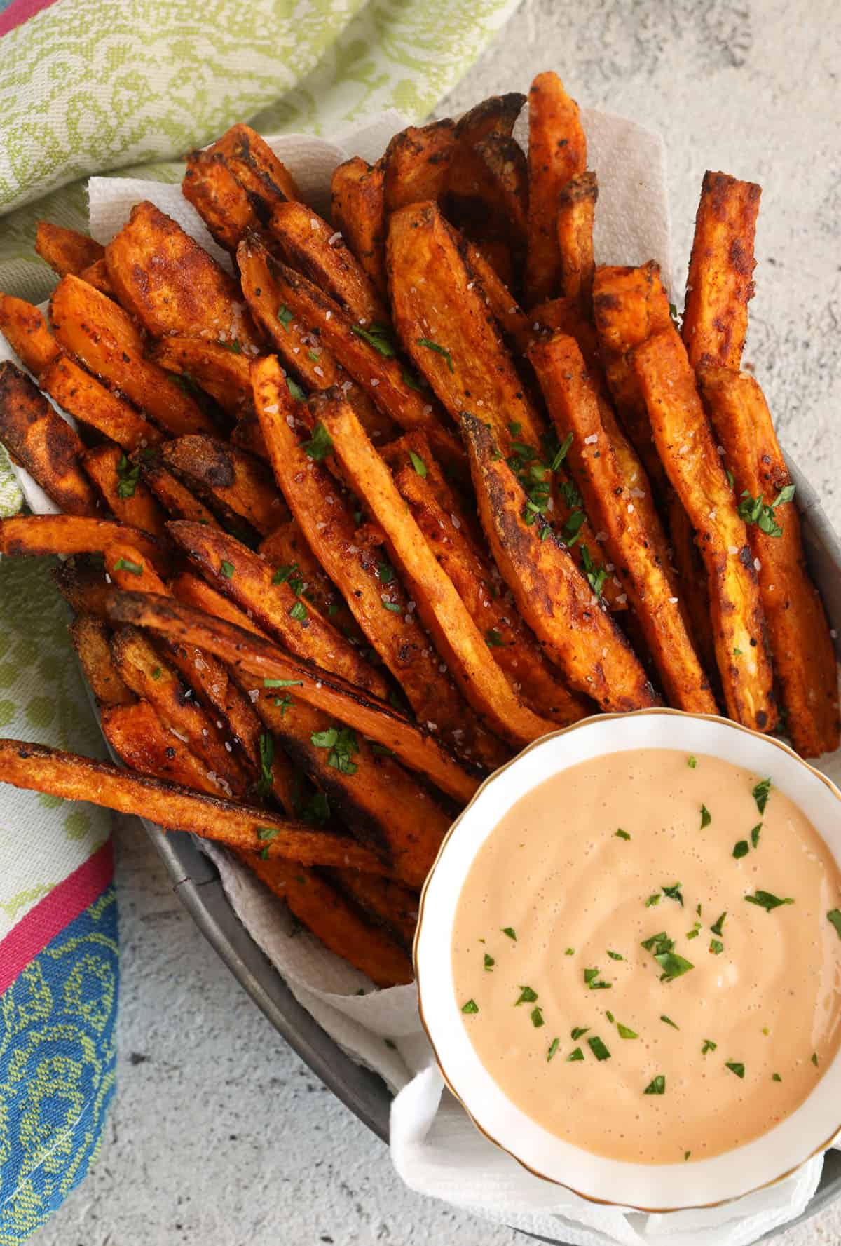 Overhead view of oven-baked sweet potato fries with dipping sauce