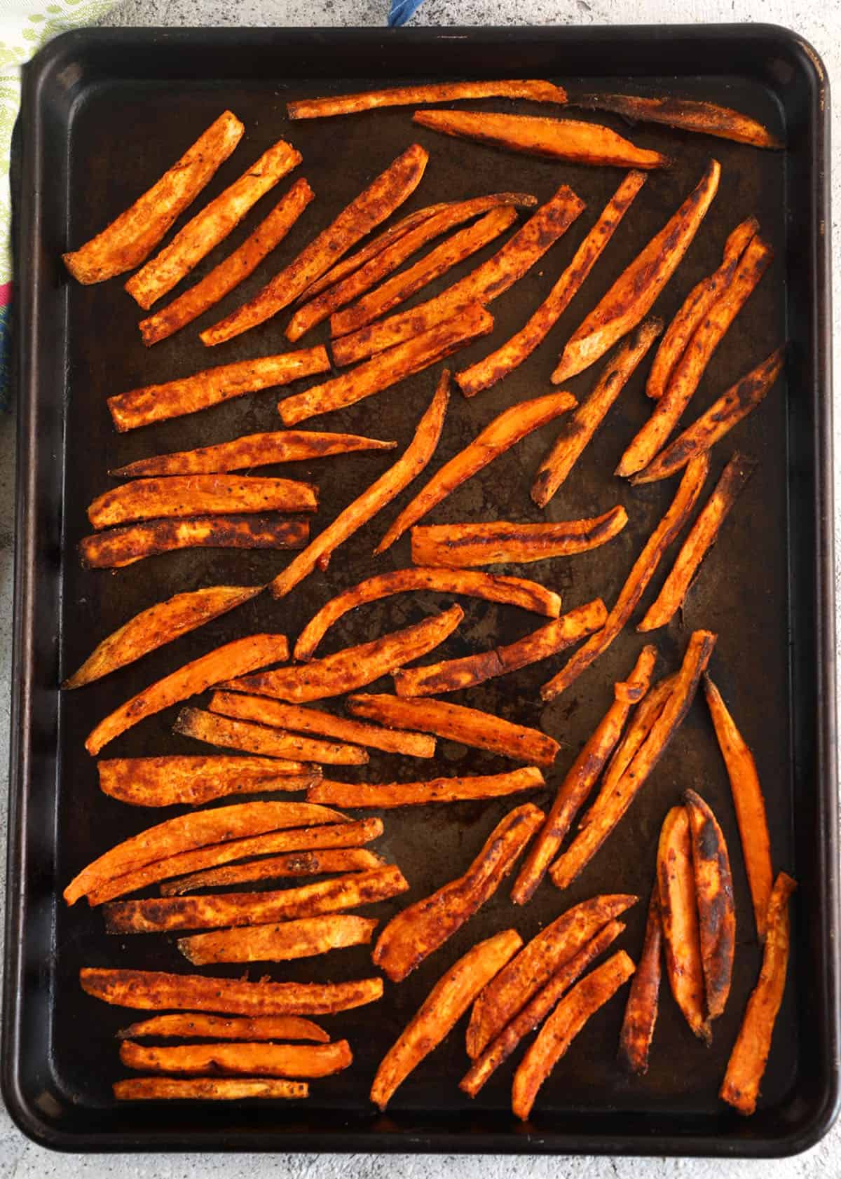 Overhead view of crispy baked sweet potato fries on sweet pan