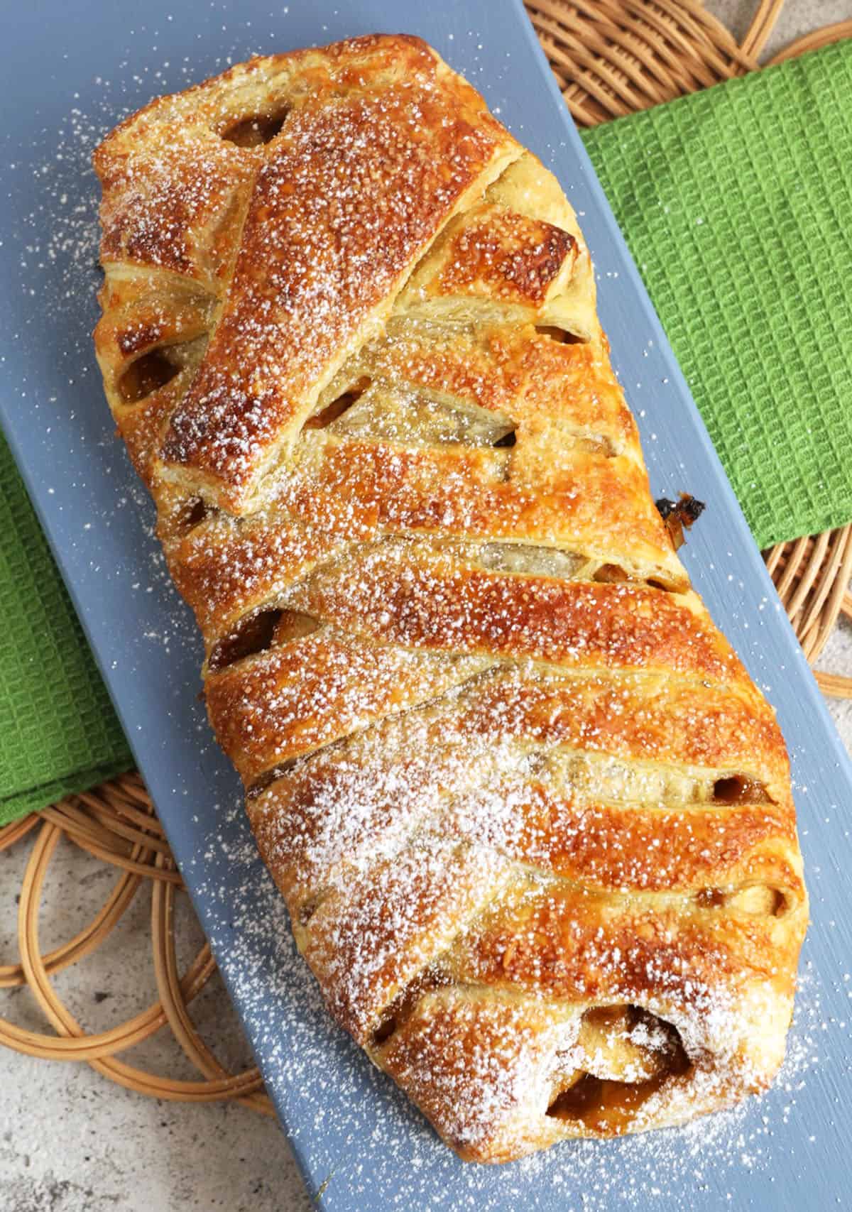 Overhead view of whole apple strudel on platter