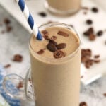 Creamy coffee smoothie in glass with straw
