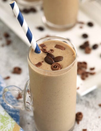 Creamy coffee smoothie in glass with straw