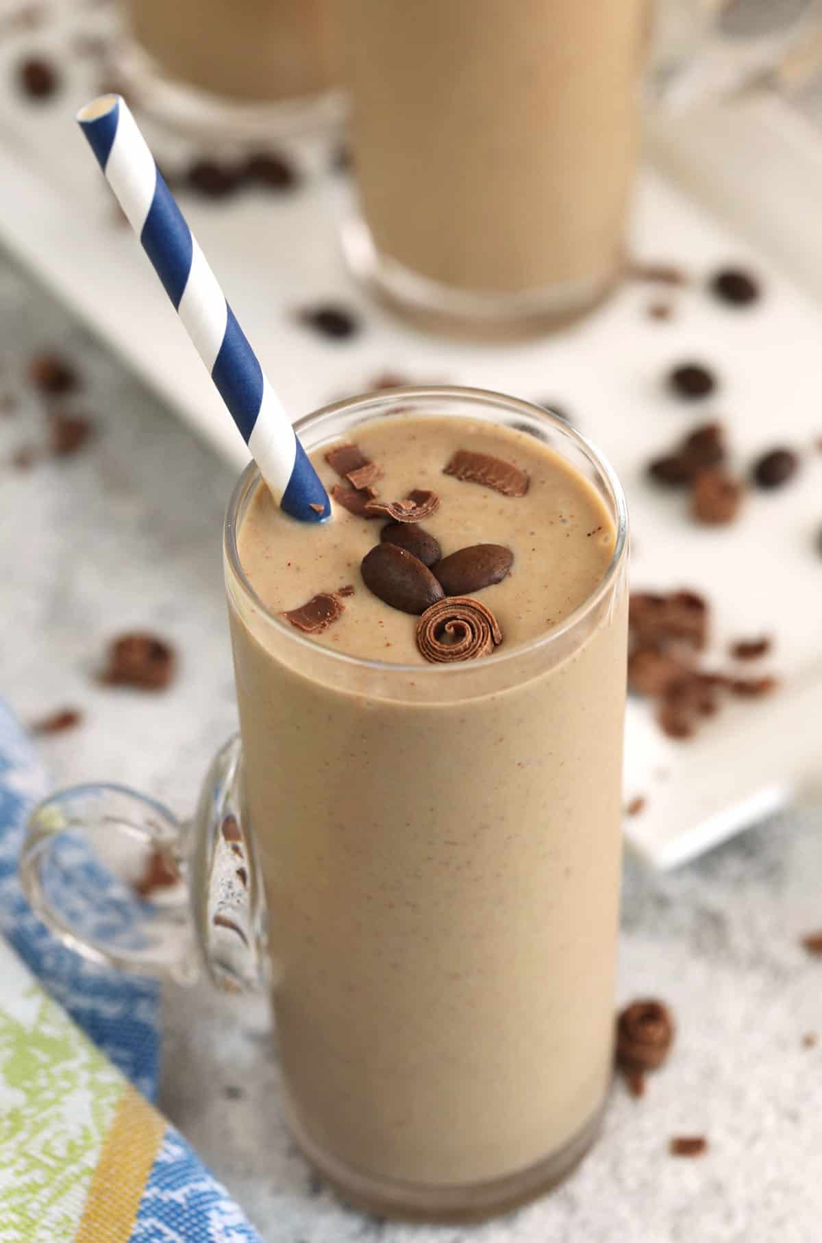 Creamy coffee smoothie in glass with straw